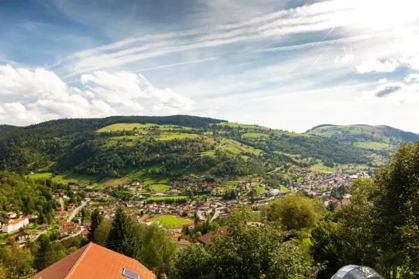 Landscape of town in valley and clouds in a blue sky, La Bresse, Vosges, France